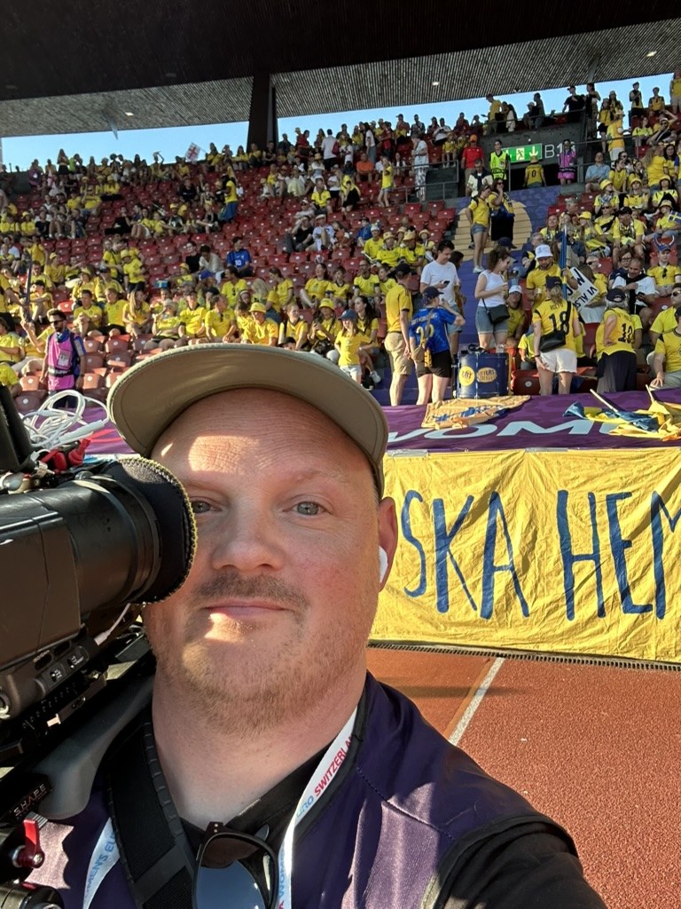 On camera beside Swedish supporters at an athletics championship